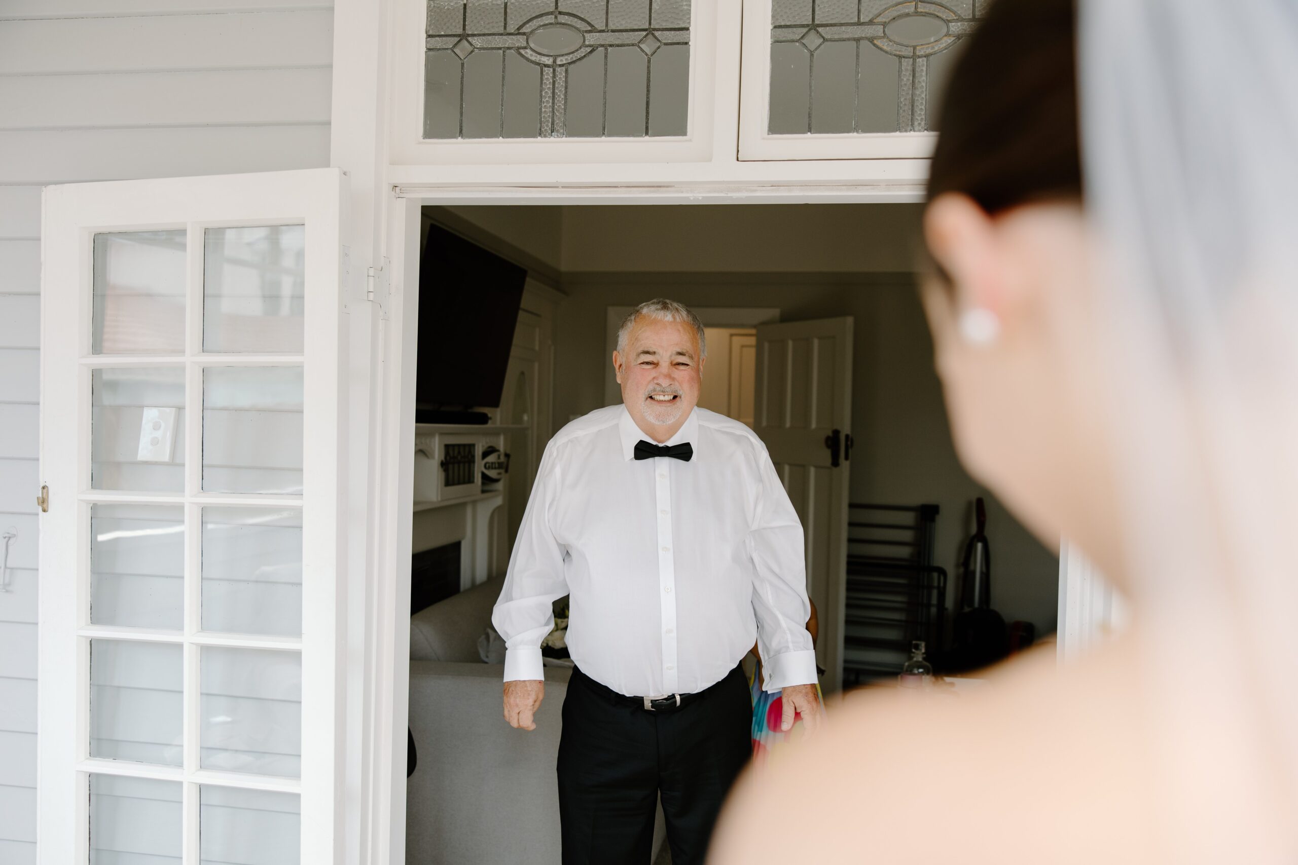 Father of the Bride seeing the bride for the first time through a door