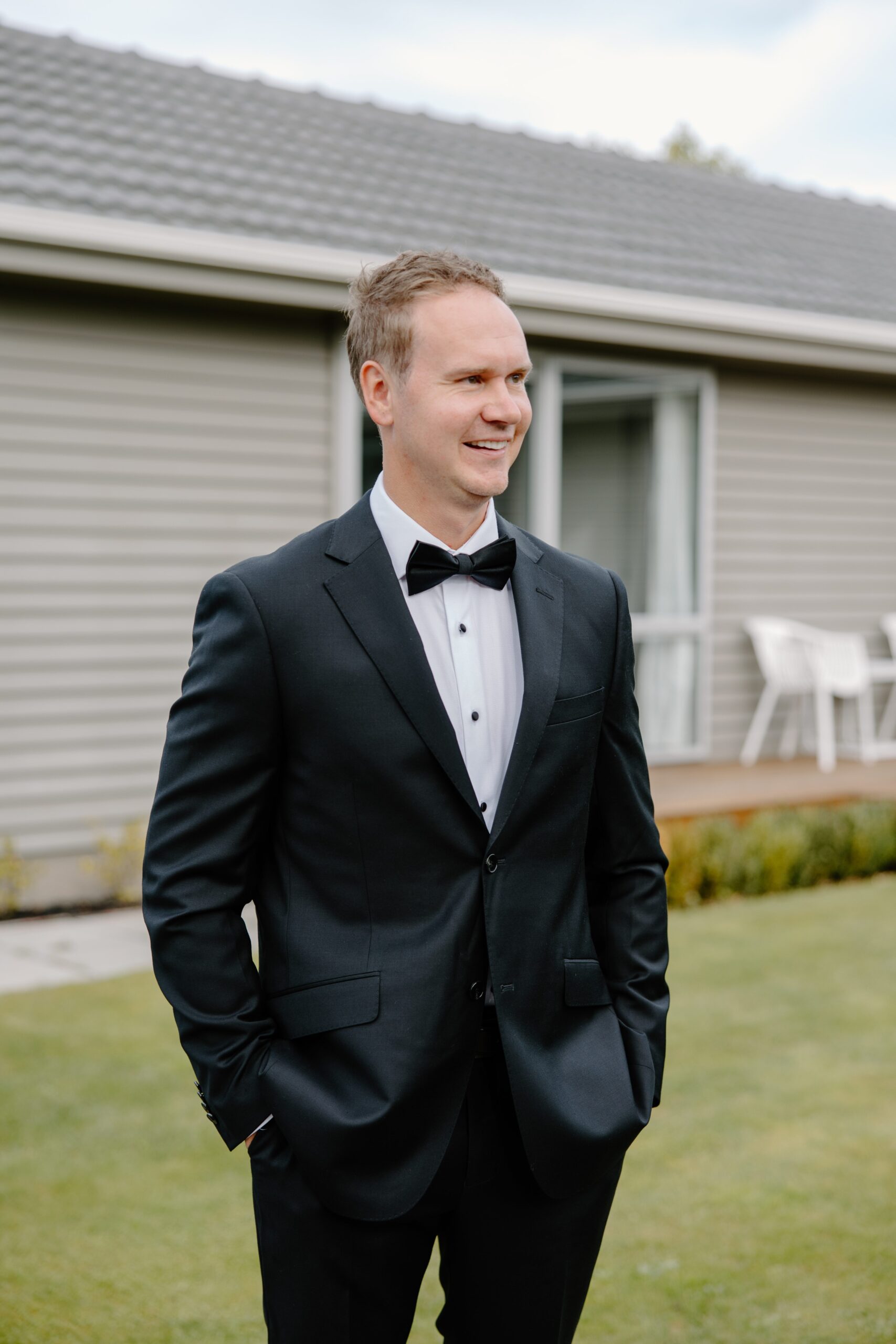 Groom standing outside a house