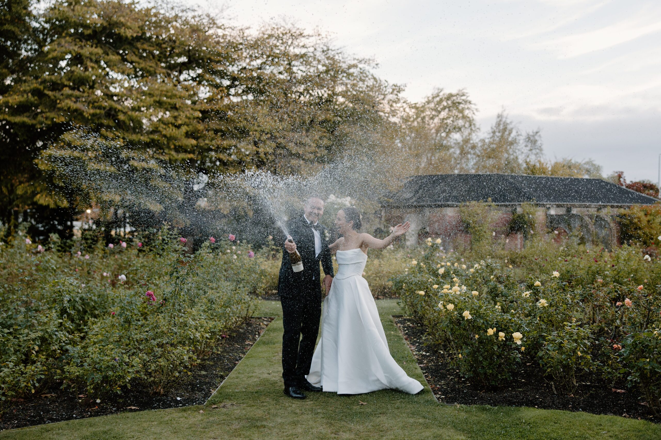 Bride and Groom spraying Champagne at Sunset in Mona Vale Gardens