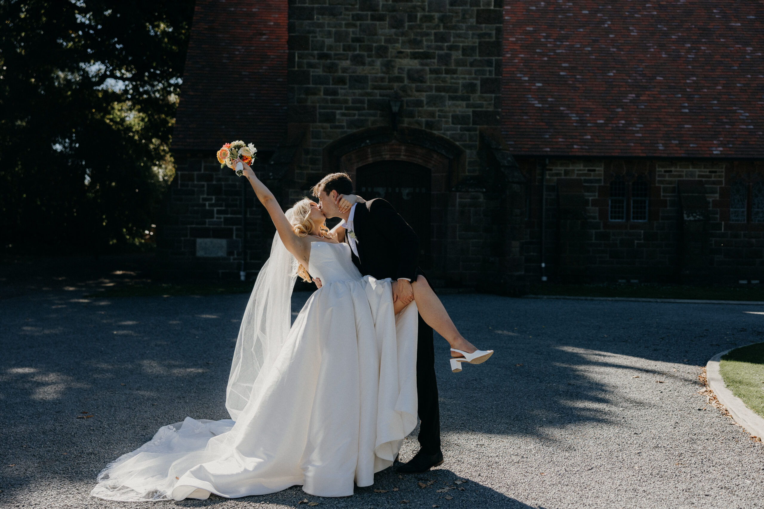 Bride and Groom kissing outside the Church at a summer Tai Tapu Hotel wedding near Christchurch.
