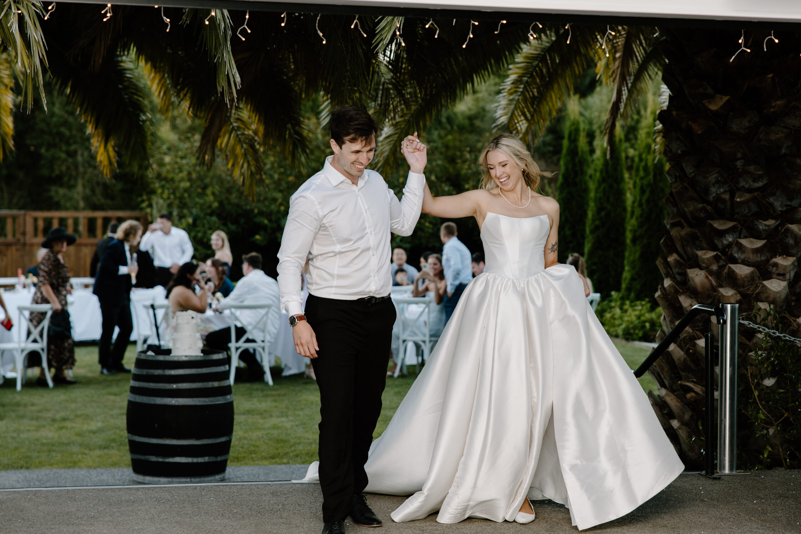Bride and groom entering their reception at a summer Tai Tapu Hotel wedding near Christchurch.